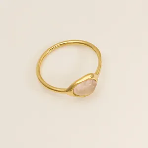 Vue détaillée d'une bague irrégulière en acier inoxydable doré avec quartz rose élégant.