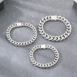 Gedetailleerd zicht op zilveren stalen Cubaanse schakelarmbanden met Beast en kruis