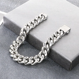 Close-up van een roestvrijstalen Cubaanse schakelarmband met Beast en kruis gravure