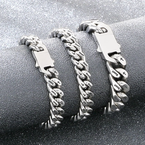 Detailweergave van zilveren roestvrijstalen Cubaanse armbanden met Beast- en kruisgravures
