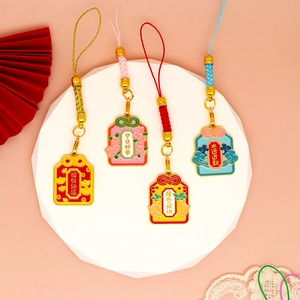 Primo piano di quattro ciondoli Omamori cinesi colorati con testi di benedizione