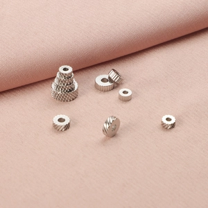 Close-up of stainless steel textured spacer beads and gear gaskets for DIY jewelry