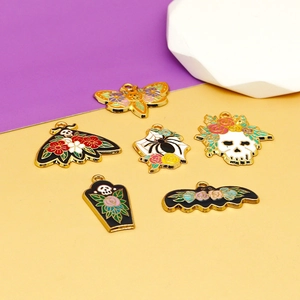 Primer plano de dijes de esmalte para Halloween con calaveras, murciélagos y arañas.