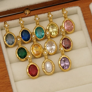 Detailed view of 12 colorful oval birthstone pendants in a wooden jewelry box.