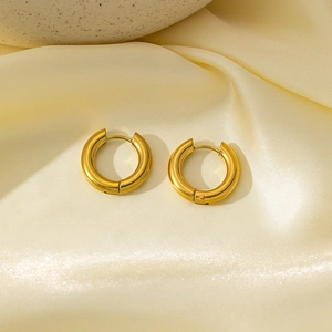 Polished chunky 18k gold plated stainless steel hoop earrings on elegant beige silk fabric