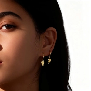 Close-up of gold heart earrings on model featuring the Best Friends engraved design