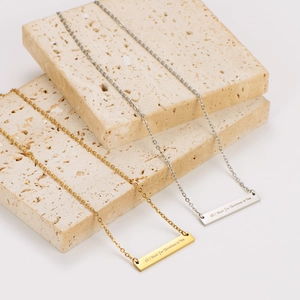 Detalle de collares de barra rectangular con grabado 'All I Want for Christmas is You'