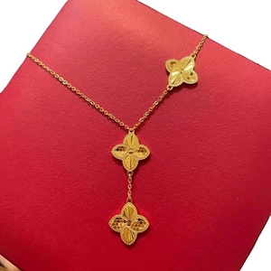 Long collier trèfle doré avec trois pendentifs à motif rayon de soleil sur boîte à bijoux