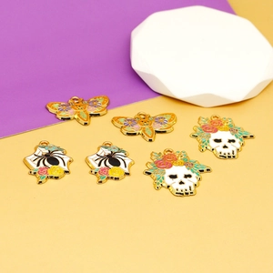 Vista detallada de dijes de esmalte de Halloween con calaveras florales y arañas