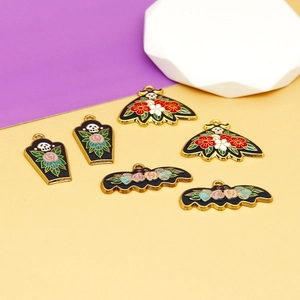 Vista detallada de dijes góticos de Halloween en esmalte con motivos florales y calaveras