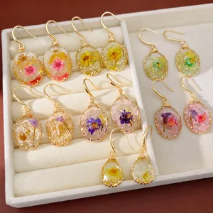 Elegant floral resin drop earrings featuring real dried flowers in oval and teardrop shapes