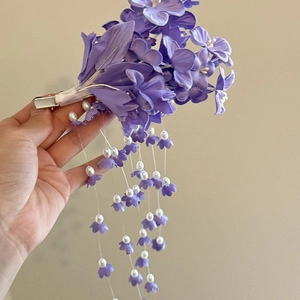 Nahaufnahme der lila Blumen-Haarklammer mit Perlenanhängern für märchenhaften Look