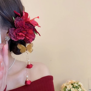Elegante rote Spinnenlilie-Haarklammer mit goldenem Schmetterlingsquasten und Perlen.
