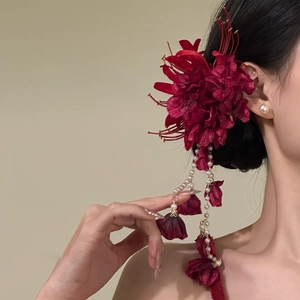 Nahaufnahme einer romantischen roten Lycoris-Haarklammer mit eleganten langen Perlenquasten