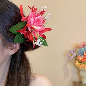 Nahaufnahme einer romantischen roten Spinnenlilien-Haarspange in schönem dunklem Haar