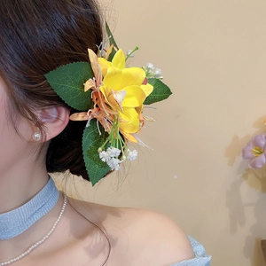 Detailansicht einer eleganten gelben Acrylblumen-Haarklammer, an einem Model getragen.