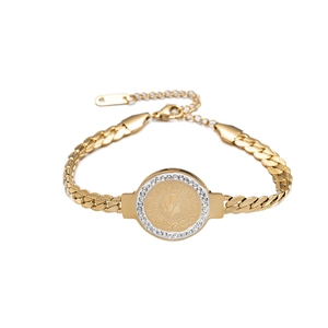 Detailed view of a gold coin pendant bracelet with crystal border and portrait relief
