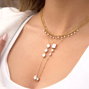 Close-up detail of a gold layered Y-shaped necklace featuring sparkling zirconia stones