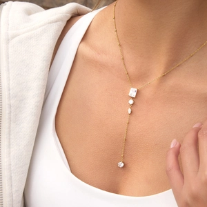 Close-up of gold-plated Y-shaped titanium steel necklace with clear zircon pendants on model