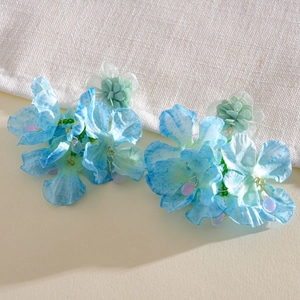 Close-up detail showing intricate blue fabric flower petals and elegant purple drop charms