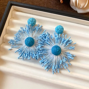 Detailed macro view of handmade blue cluster flower petal earrings with silver needles
