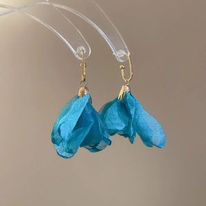Detailed view of elegant blue fabric flower petal cluster earrings with gold hooks