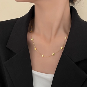 Elegant gold titanium steel clover and star pendant necklace worn on a female model