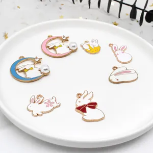 Vue détaillée de diverses breloques en émail lapin avec des accents de lune et de perles