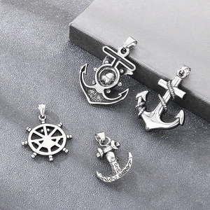 Detail view of four vintage nautical pendants including anchors and ship wheels.