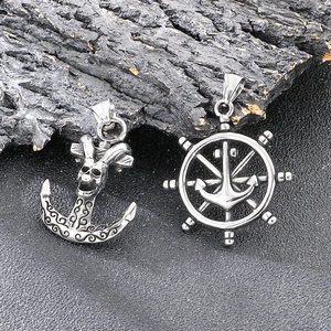Detailed macro shot of vintage punk skull anchor and nautical ship wheel steel pendants