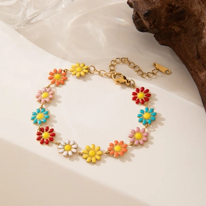 Detalle de una pulsera de flores de margarita en esmalte colorido y cadena dorada