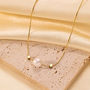 Elegant gold pearl necklace with geometric accents on luxury silk and stone background