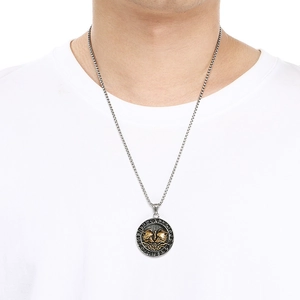 Close-up detail of Norse Viking wolf and raven totem pendant necklace on model wearing white shirt