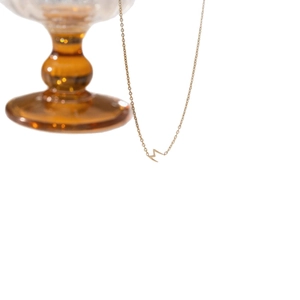 Collier minimaliste en acier titane doré avec un pendentif moderne en forme de M