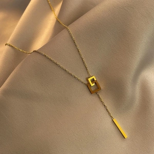 Elegant gold square link titanium necklace with Y-shape tassel pendant on silk background