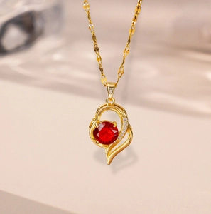 Elegant 18k gold heart necklace with a faceted red gemstone and micro-pave crystals