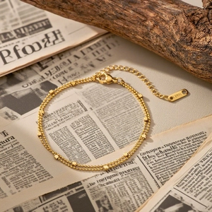 Bracelet double couche en acier inoxydable doré avec breloques carrées sur fond vintage