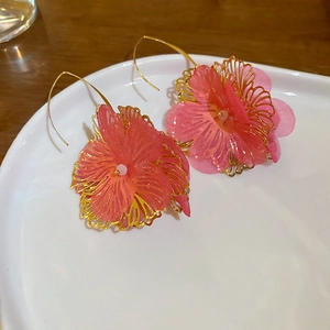 Élégantes boucles d'oreilles en fleur de soie rose avec base de feuille dorée