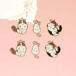 Six cute enamel cat charms with golden edges on a soft pink background
