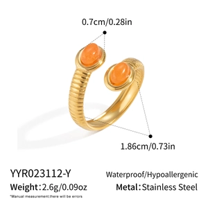 Macro detail of 18K gold-plated stainless steel ring with orange stone and ribbed texture