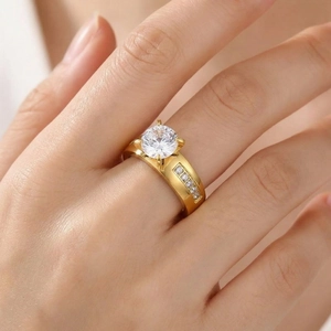 Close-up detail view of elegant gold stainless steel four-prong cubic zirconia ring on finger