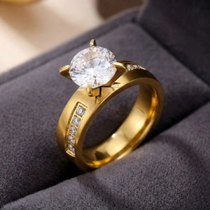 Close-up macro detail of a gold-plated stainless steel four-claw ring with a large center stone
