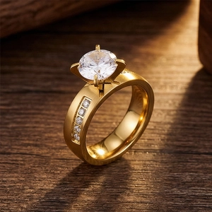 Macro view of four-prong gold stainless steel ring with round sparkling diamond