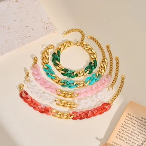 Close-up of colorful acrylic and gold metal chunky chain bracelets in various vibrant shades.