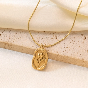 French vintage gold tulip embossed oval pendant on a sleek snake chain necklace