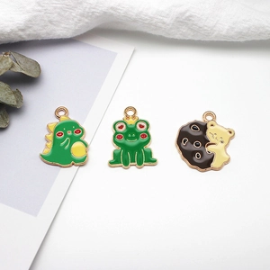 Detail view of cute alloy enamel charms including dinosaur, frog and cute hugging bear.