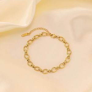 Close-up of 18K gold plated Cuban chain necklace with lobster clasp on silk fabric