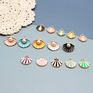 Gedetailleerd overzicht van diverse kleurrijke emaille schelphangers met parels voor DIY.