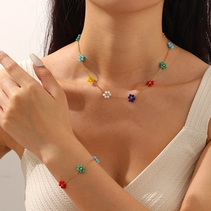 Detailed view of women's colorful beaded daisy flower necklace and bracelet set