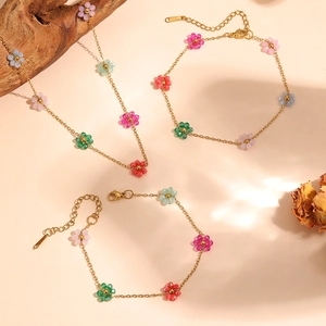 Detailed view of colorful beaded flower necklace and bracelet set in gold-tone steel